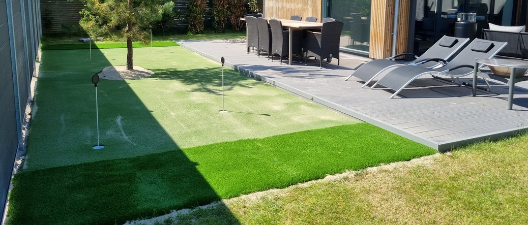 Golfdesign Clock green med stenkant og kunstgræs i haven